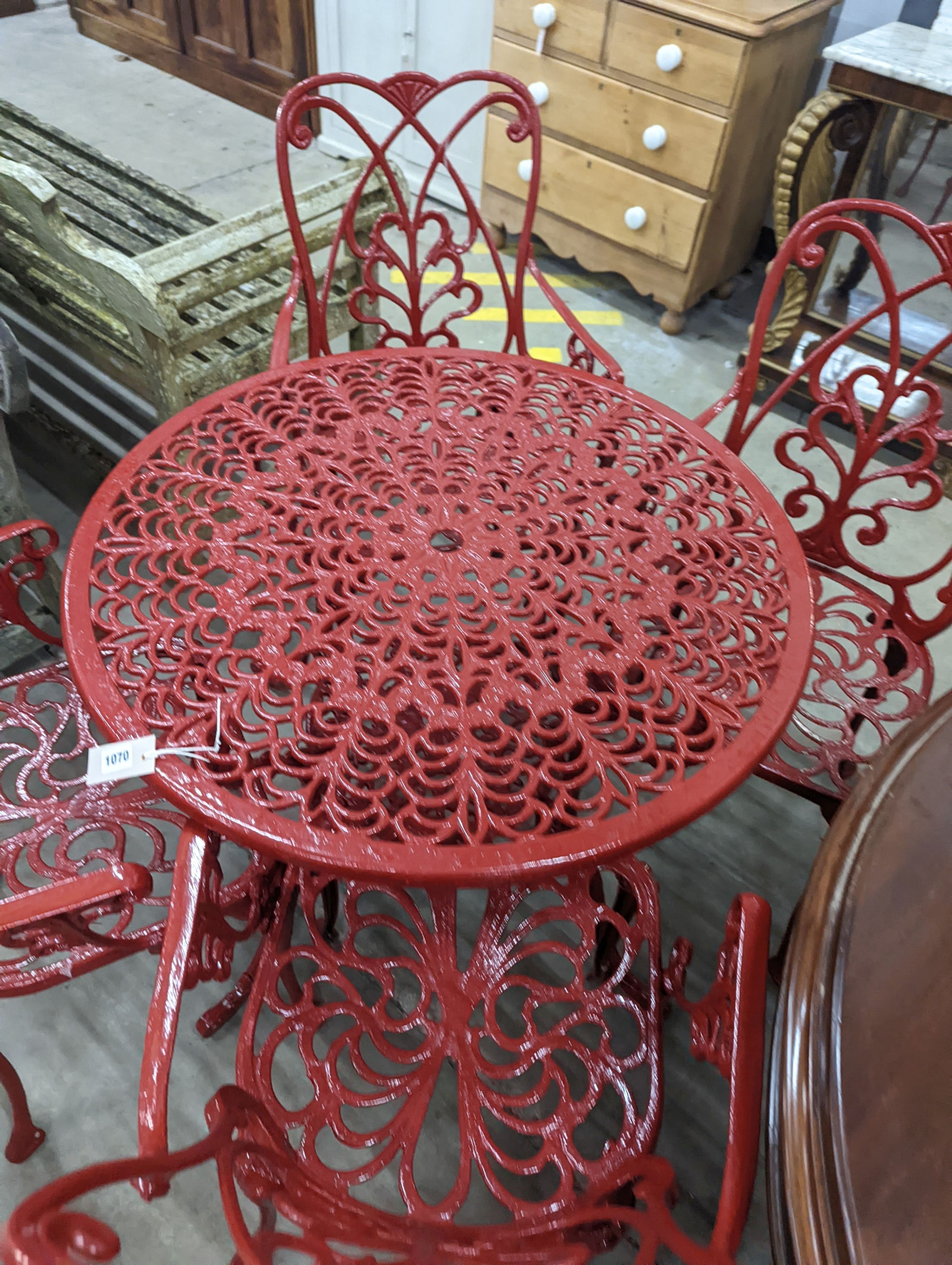 A circular red painted aluminium garden table, diameter 86cm, height 67cm together with four matching chairs